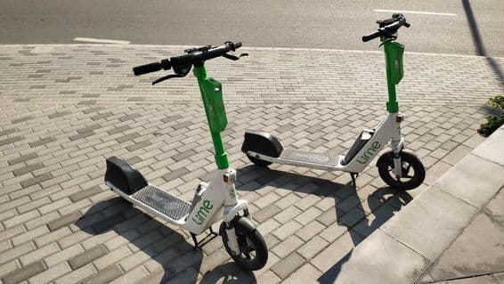 Scooters Lime estacionadas em uma rua de Dubai.