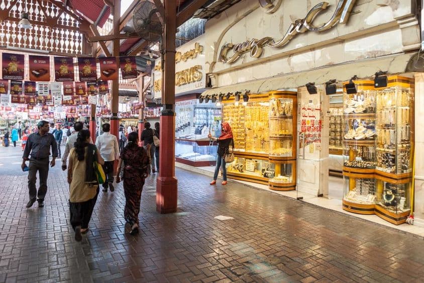 Mercado de ouro de Dubai, uma loja exibindo joias de ouro, com pessoas passando.