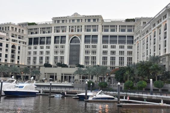 Hotel Palazzo Versace de Dubai, com barcos a motor balançando na água por perto.
