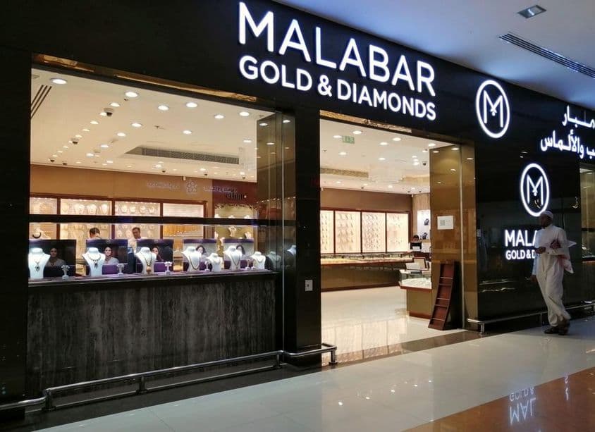 Um emiradense em frente à vitrine da loja Malabar Gold & Diamonds.