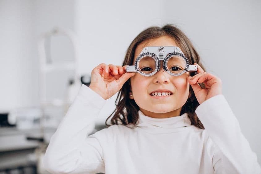 Menina com deficiência visual usando óculos de teste em uma ótica.