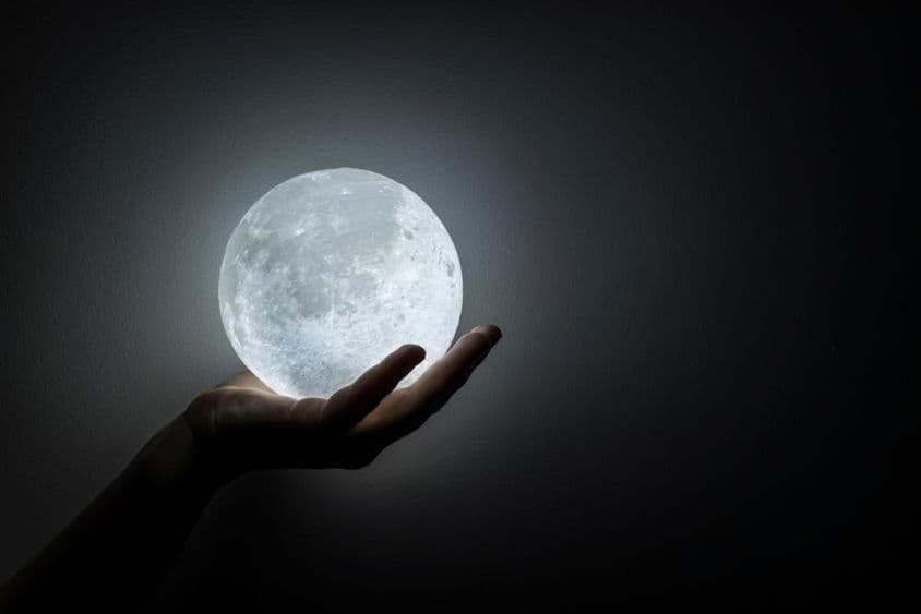 Uma mão segurando a lua.
