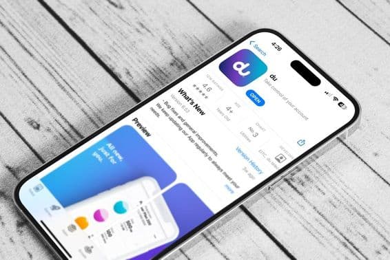 Um celular em uma mesa, rodando o aplicativo móvel da du.