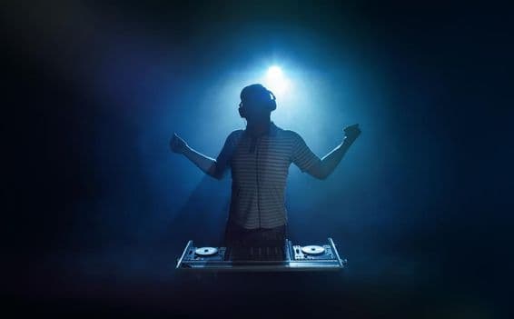 Uma pessoa está atrás da cabine do DJ.