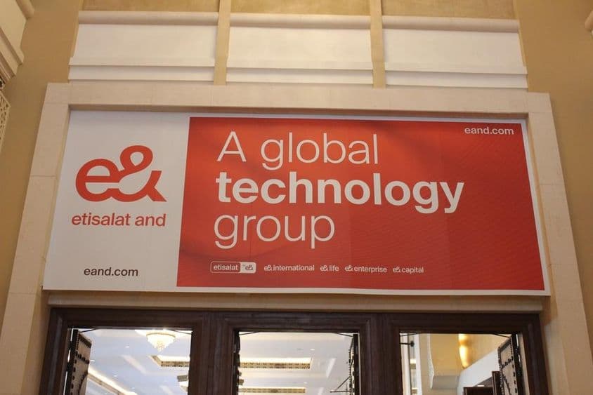 Anúncio da empresa Etisalat acima de uma vitrine com porta de vidro visível.