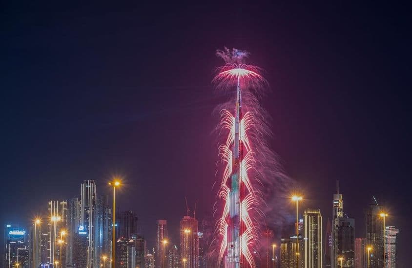 Fogos de artifício de Ano Novo no Burj Khalifa com outros arranha-céus iluminados.