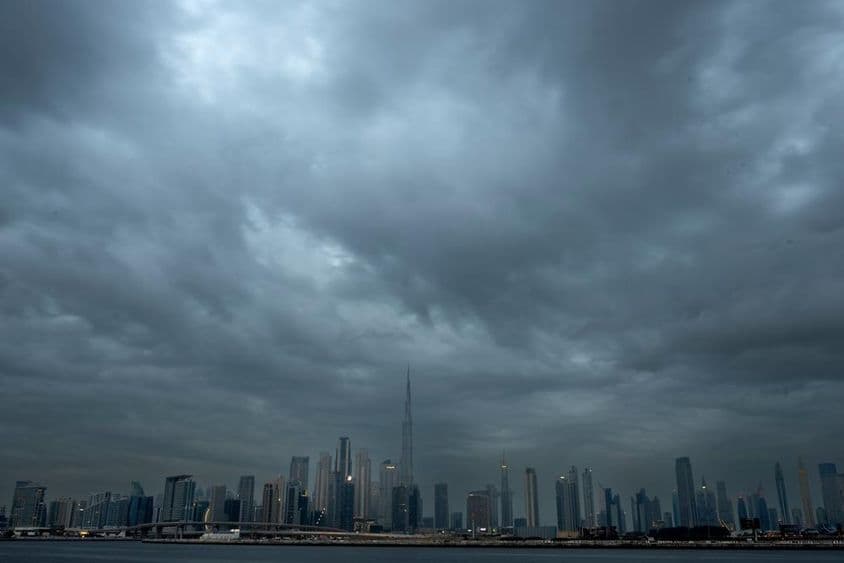 Céu nublado com um fundo de arranha-céus, Burj Khalifa no centro.