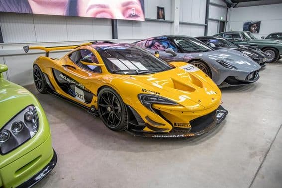 McLaren e outros carros estacionados em uma garagem.