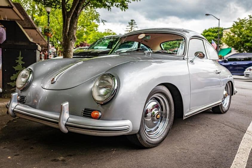 Um Porsche 356A é visto estacionado sob uma árvore.