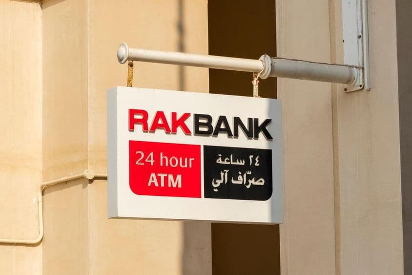 Placa de caixa eletrônico do RAKBANK em texto vermelho e parcialmente preto.