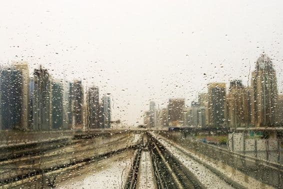 Janela molhada de chuva com vista para arranha-céus.