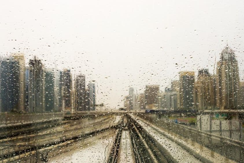 Janela molhada de chuva com vista para arranha-céus.