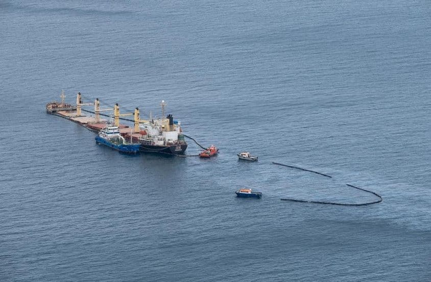 Limpeza de derramamento de óleo no mar, barcos cercando a área.