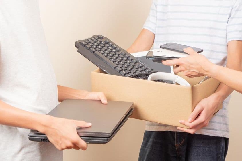 A imagem mostra laptops, telefones e peças de computador doados.