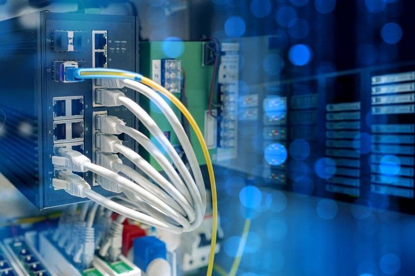 Cabos UTP pendurados em um roteador dentro de um data center.