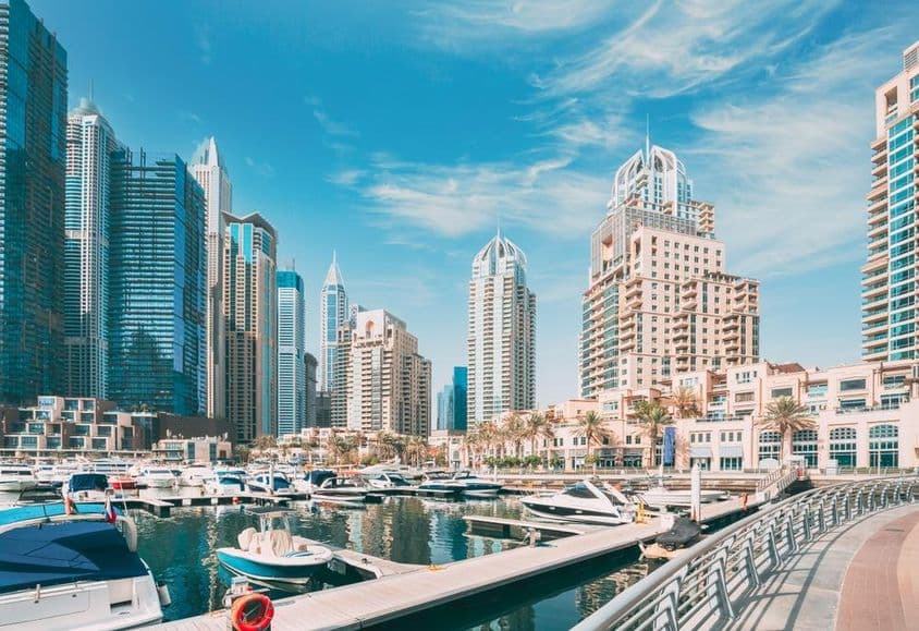Horizonte de Dubai Marina com barcos no porto e arranha-céus ao fundo.