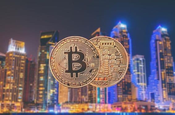 Moedas de Bitcoin em primeiro plano com arranha-céus ao fundo.