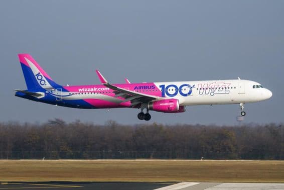 Avião da Wizz Air voando em baixa altitude sobre a pista.