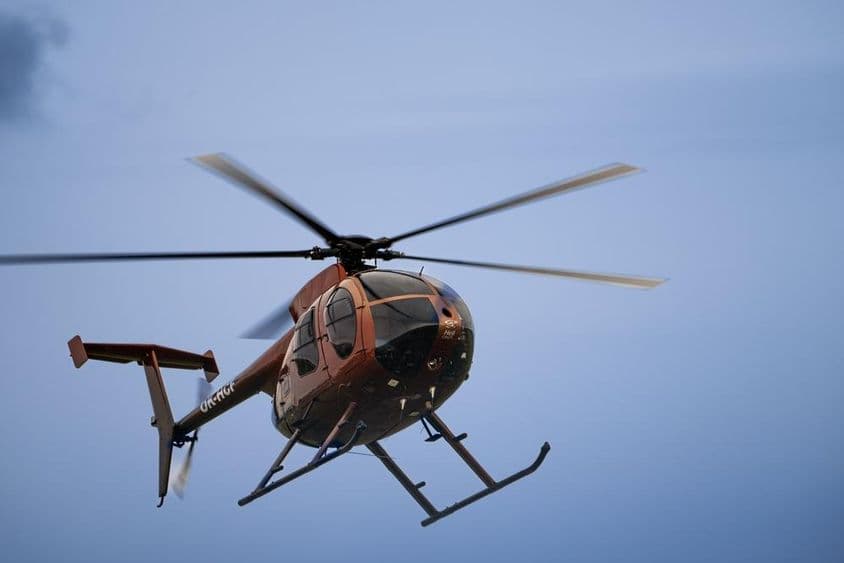 Um helicóptero leve voando no ar.