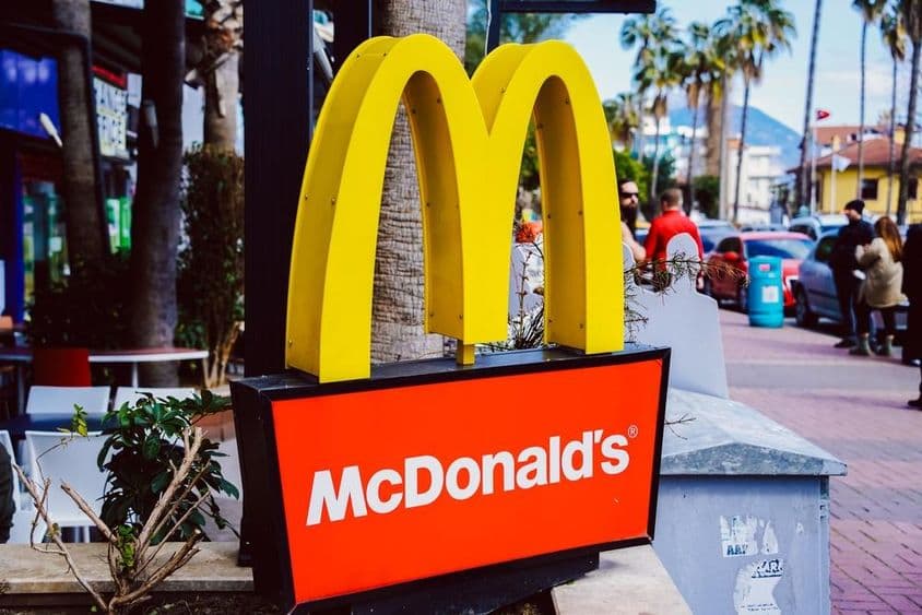 Placa do McDonald's visível com vista da rua ao fundo.