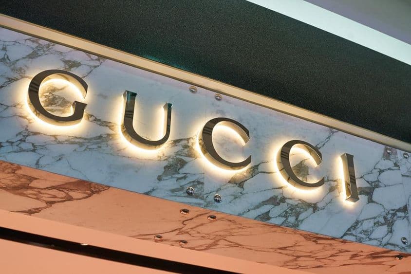 Sinal da Gucci em letras iluminadas na fachada de uma parede.