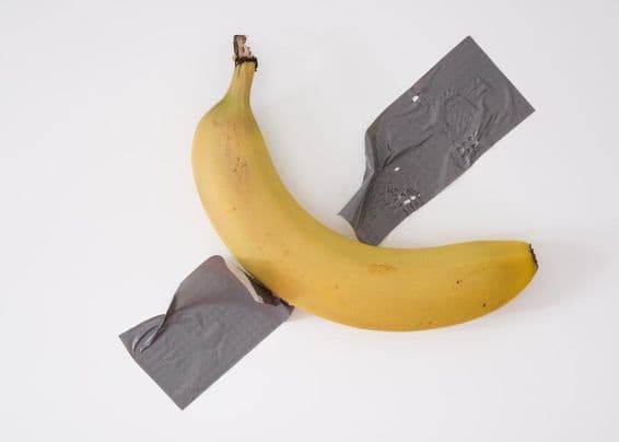 Uma banana presa à parede com fita adesiva cinza.