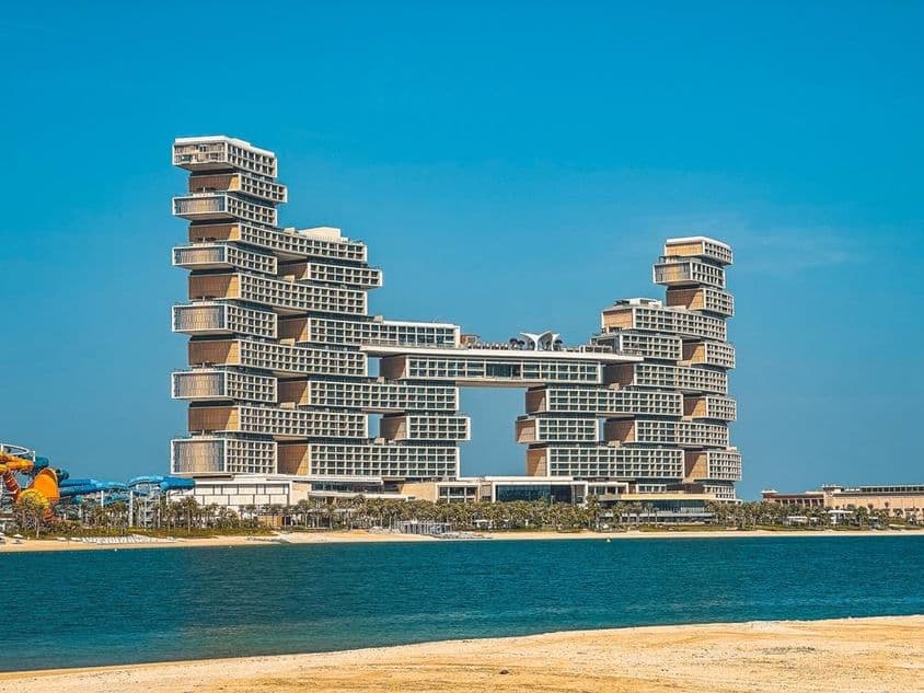 Hotel Atlantis The Royal ao fundo com água e praia em primeiro plano.