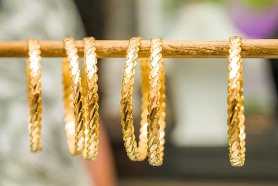 Pulseiras de ouro 24 quilates enfiadas em uma haste.