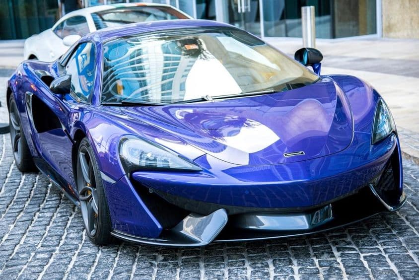 Carro azul da McLaren estacionado em uma rua de Dubai.