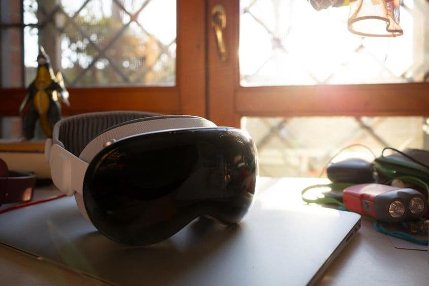 Apple Vision Pro sobre um caderno em uma mesa.