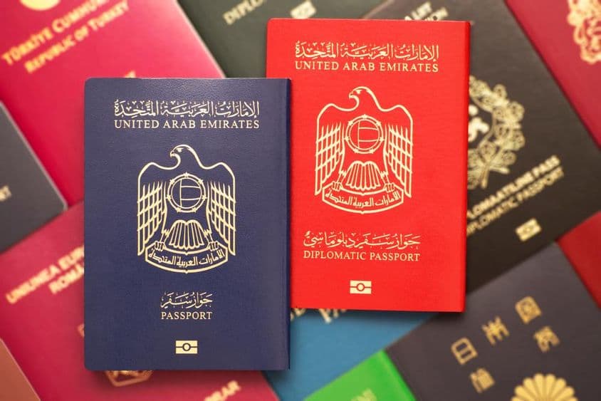 Passaportes empilhados com passaportes dos Emirados Árabes Unidos no topo.