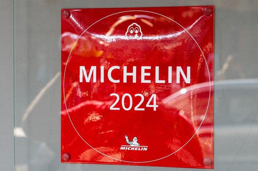 Uma placa do Guia Michelin 2024 vista na parede de um restaurante.