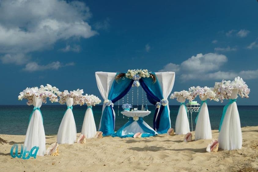 Casamento na praia sobre areia com flores e pequena mesa