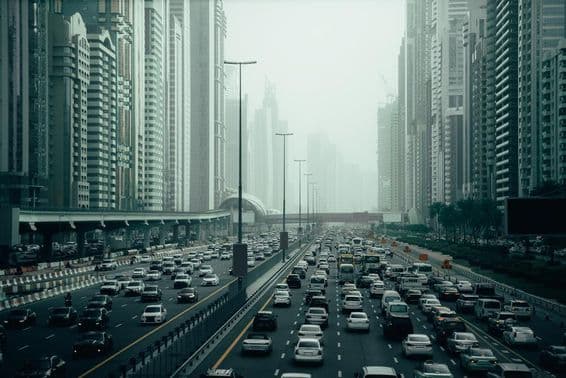 Rodovia movimentada de Dubai na cidade, 2x7 pistas, arranha-céus dos dois lados.