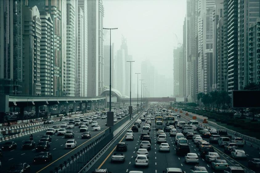 Rodovia movimentada de Dubai na cidade, 2x7 pistas, arranha-céus dos dois lados.