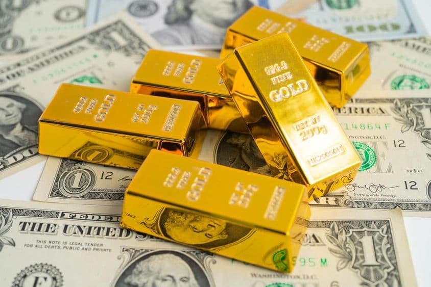 Barras de ouro de investimento pesando 200g sobre dólares americanos.