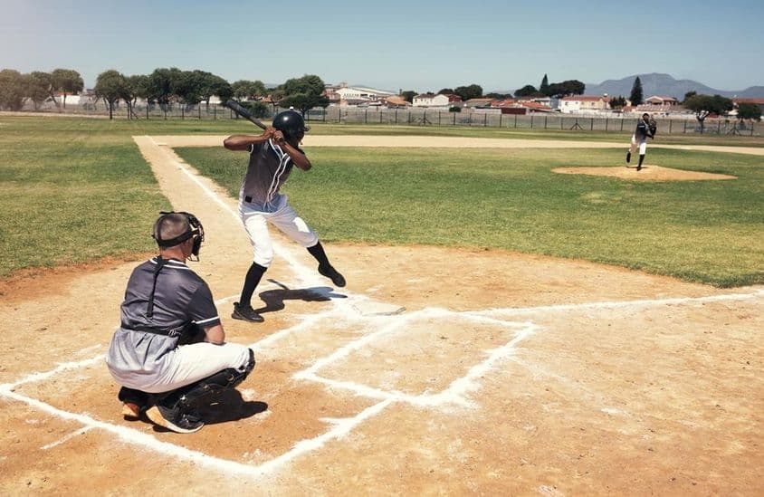 Um jogador de beisebol aguarda um lançamento do arremessador.