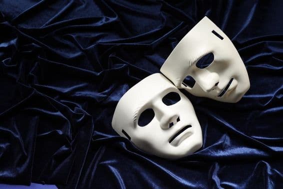 Teatro, duas máscaras brancas sobre veludo azul.