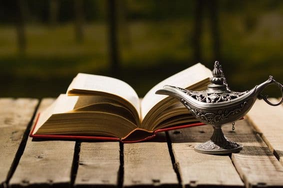 Livro aberto e uma lâmpada antiga.