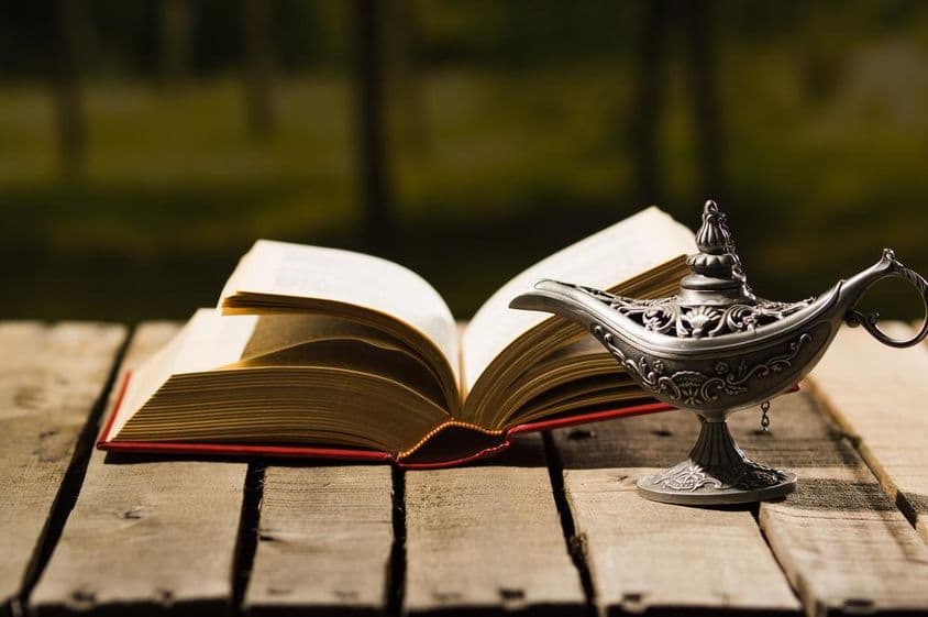 Livro aberto e uma lâmpada antiga.