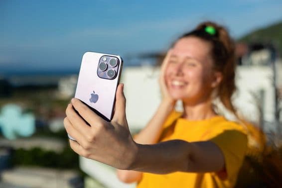 Jovem segurando um iPhone.