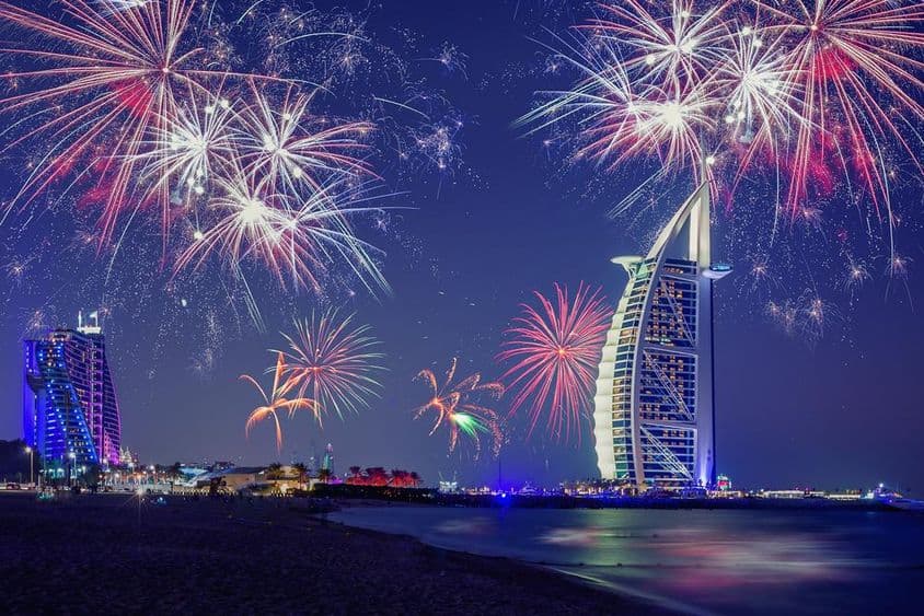 Ano Novo em Dubai com Burj Al Arab e fogos de artifício ao fundo.