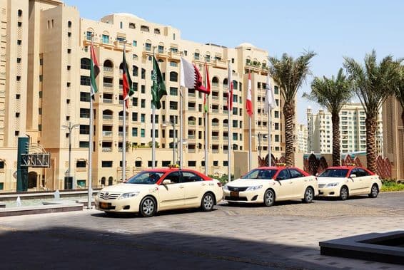 Táxis de Dubai em frente a um edifício residencial de 10 andares.