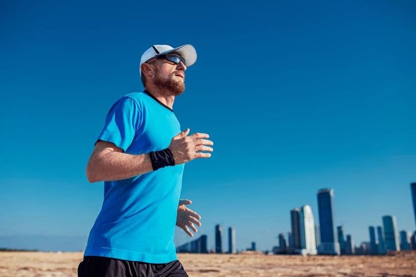 Triathlon em Dubai, um homem correndo com arranha-céus ao fundo.