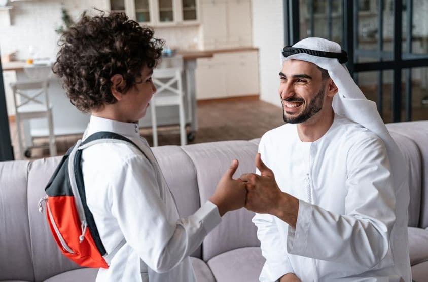 Pai e filho árabes se preparando para a escola.