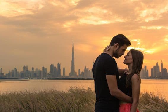 Jovem casal com o horizonte de Dubai ao fundo.