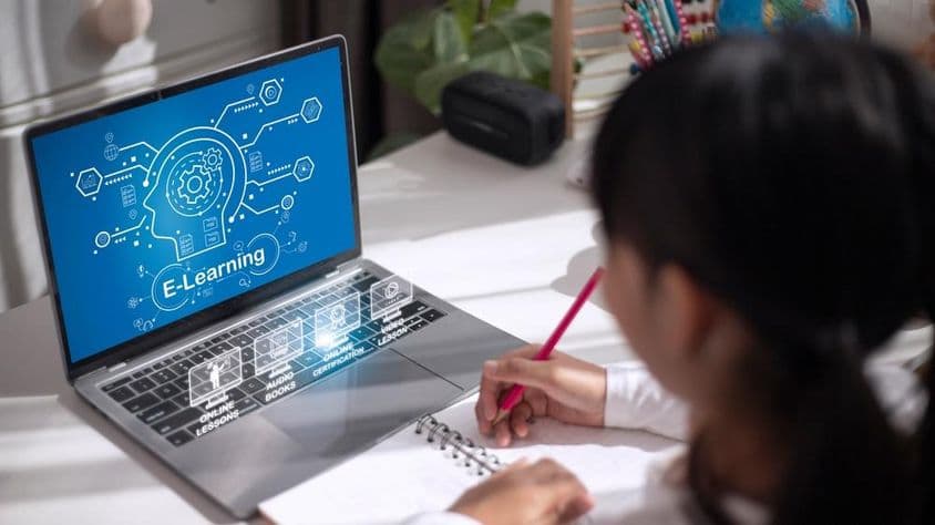 Garota estudando material educativo em casa.