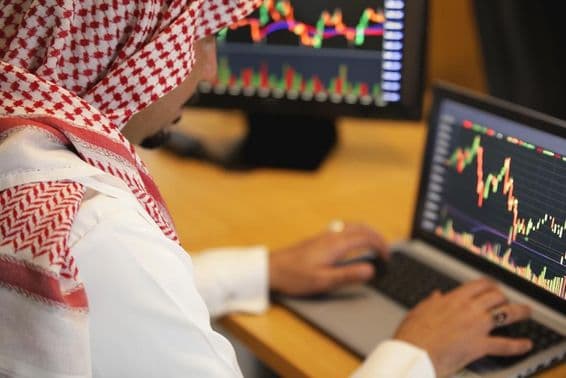 Homem árabe trabalhando em um laptop.