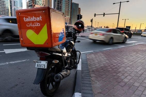 Motocicleta da Talabat estacionada na beira da estrada.