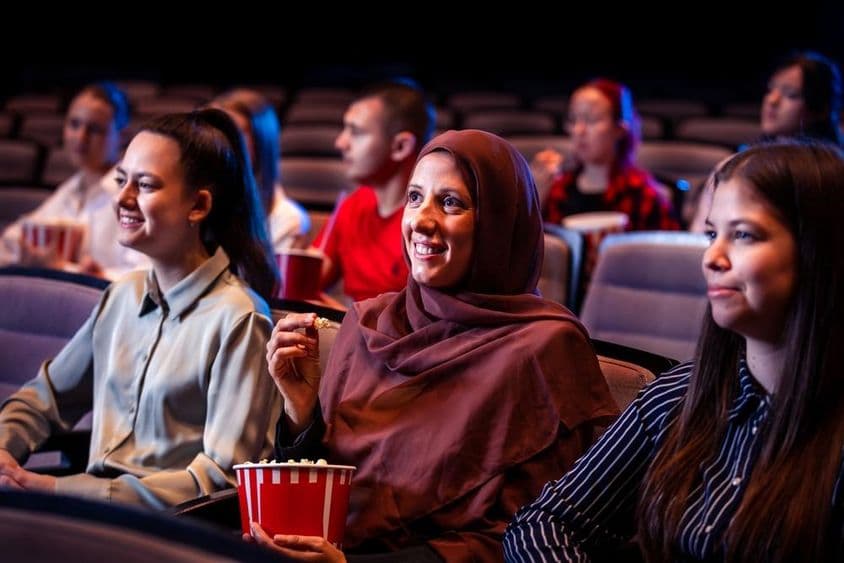 Mulher muçulmana apreciando o cinema.